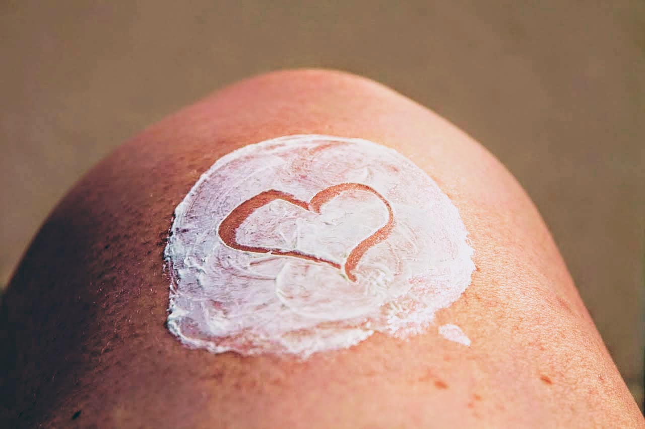 l'image représente un genou couvert de crème solaire
