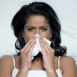 L'image représente une femme en train de se moucher.