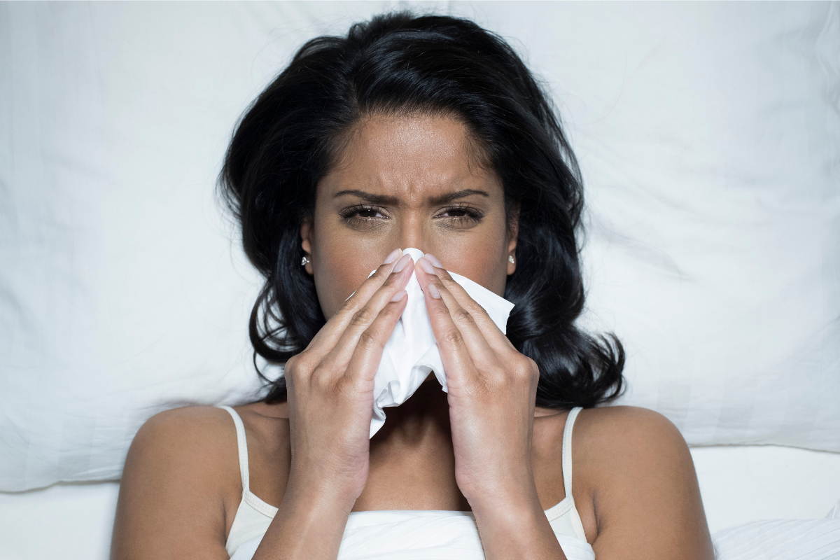 L'image représente une femme en train de se moucher.