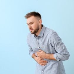 L'image représente un homme plié en deux qui souffre de douleurs liées à la gastro.