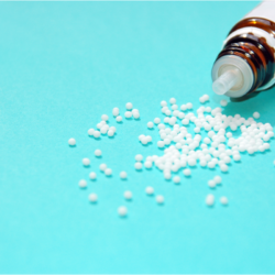 L'image représente un flacon de remède homéopathique pour l'infertilité qui se déverse sur un fond bleu.