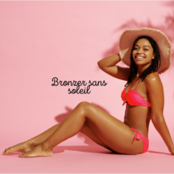 Femme souriante en bikini rose avec un teint hâlé obtenu grâce à un autobronzant naturel, posant sur fond rose avec chapeau de soleil