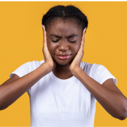 Femme se tenant les oreilles, exprimant la douleur ou l'inconfort.