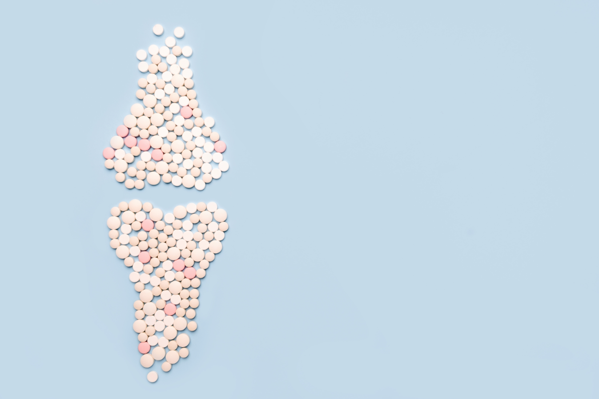 Représentation créative de pilules et de comprimés disposés sur un fond bleu clair pour former une image où l'on reconnaît un os et un cœur, symbolisant les suppléments pour la santé osseuse et cardiaque dans le contexte de la lutte contre l'ostéoporose.