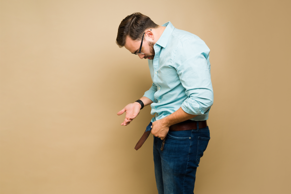 Homme adulte regardant sa braguette ouverte avec inquiétude, symbolisant un problème d’érection ou de dysfonction érectile