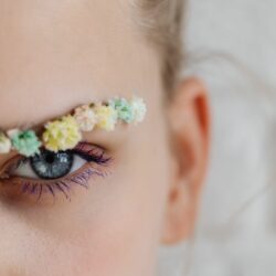 une femme avec des sourcils décorés avec des fleurs pour mettre en valeur la beauté de ses cils