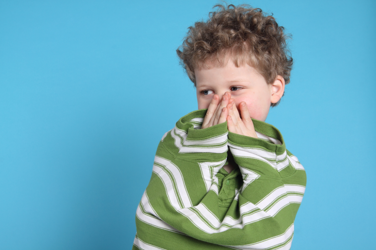 L'image représente un petit garçon qui se cache le visage. il a probablement peur qu'on lui fasse mal en désinfectant ses bobos.