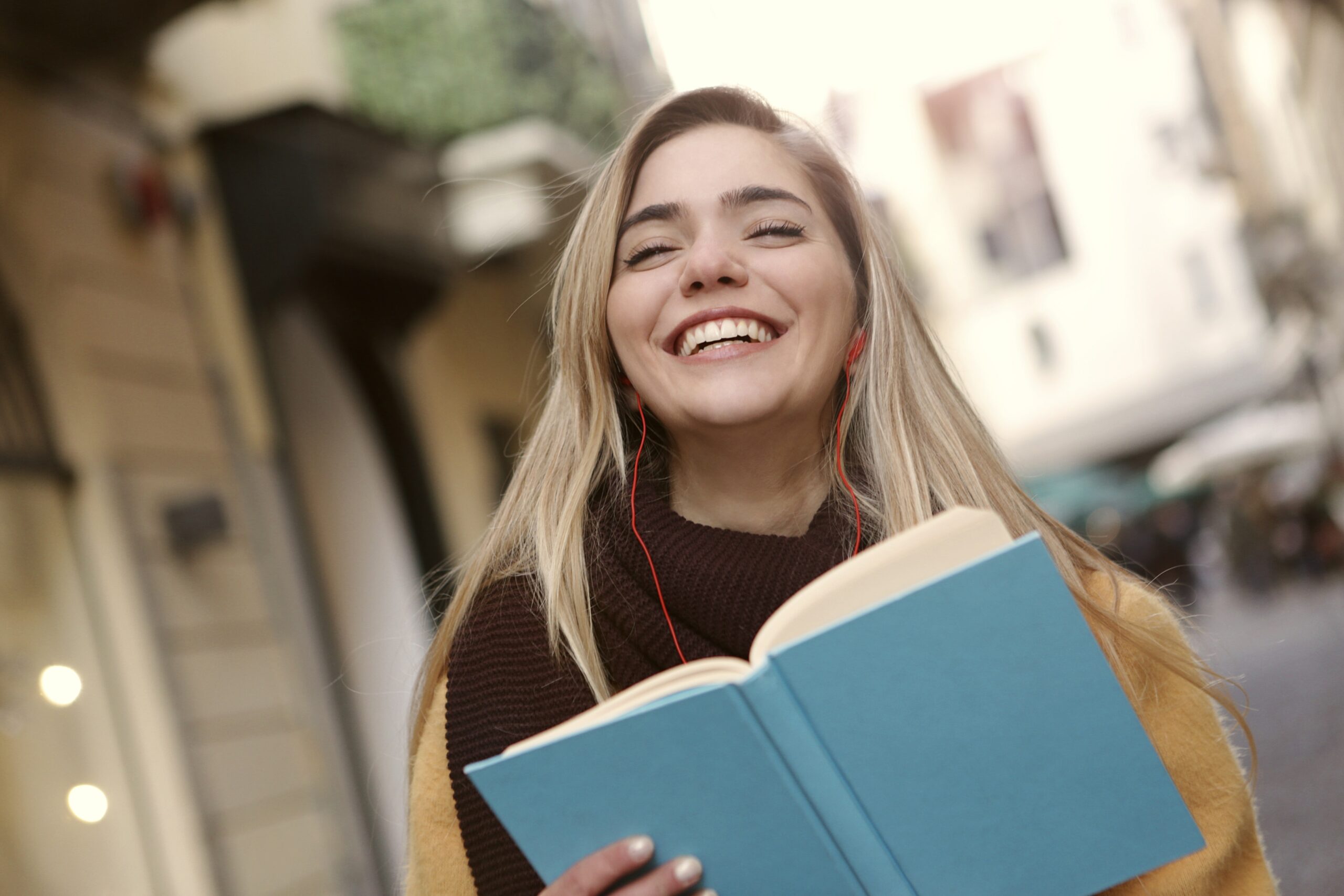 une jeune fille qui tient un cahier en souriant