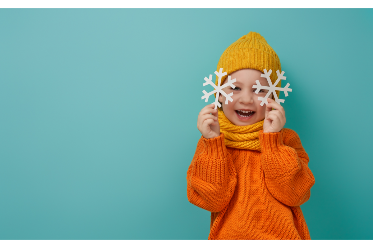 L'image représente un petit garçon souriant, avec un bonnet, une écharpe et deux flocons de neige fictifs dans les mains. Quels bourgeons choisir pour passer l'hiver sereinement?