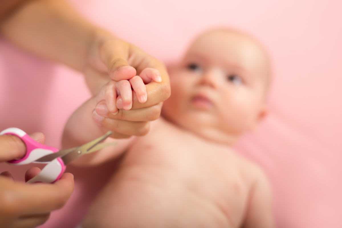 Comment couper les ongles de Bébé sans danger. une personne en train de couper les ongle son bébé en toute sécurité