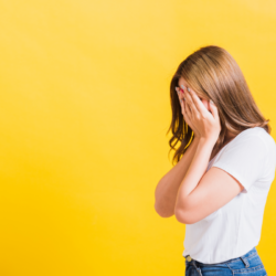 L'image représente une femme qui se tient le visage avec les mains et se demande comment éviter la déprime d après fêtes ?