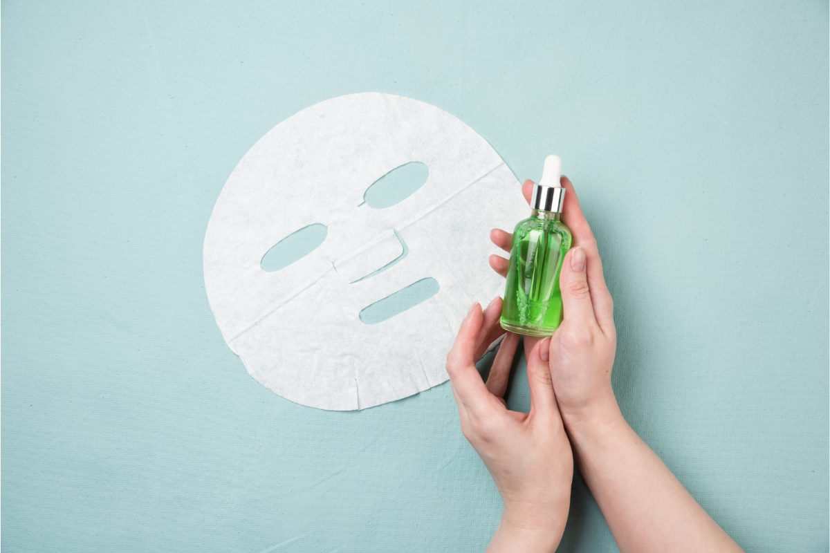 L'image représente un masque à usage unique et les mains d'une personne qui tient un flacon de sérum. Très certainement un traitement pour apaiser la dermite séborrhéique. Comment soigner la dermite séborrhéique