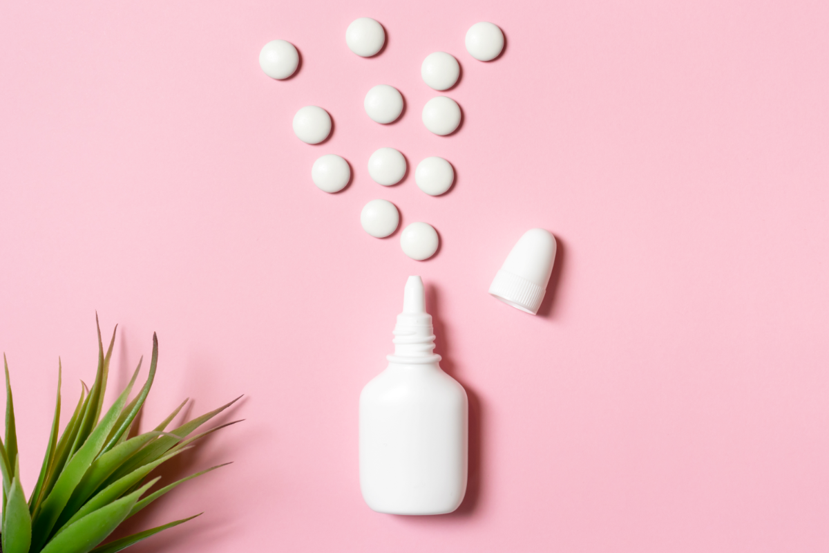 La congestion nasale : comment s'en débarrasser. L'image représente un flacon pour soigner les problèmes de congestion nasale. Des comprimés blancs semblent sortir de ce contenant. L'image a un fond rose et on peut voir une plante dans le coin gauche en bas.