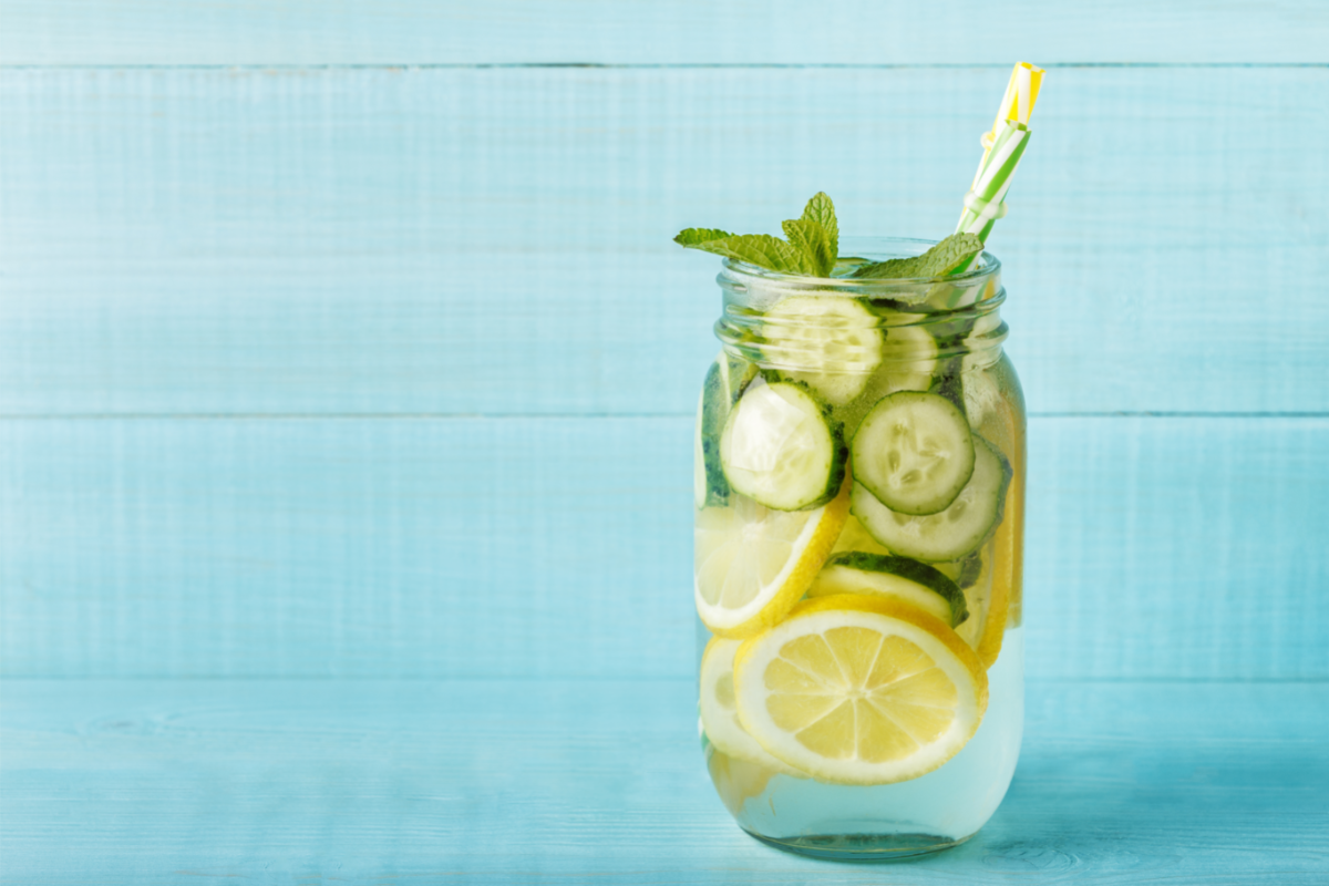 L'image représente un verre avec une boisson ç base de rondelles de concombre et de citron. détox du sang