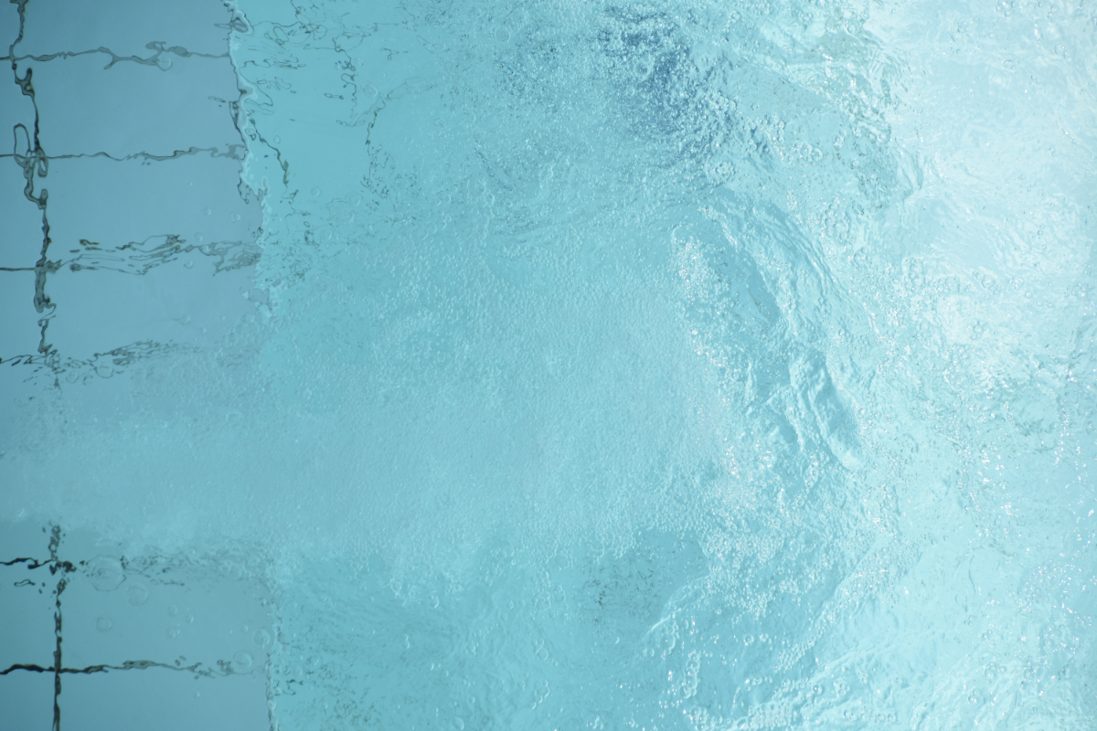 Cette image montre l'eau en mouvement, avec des bulles d'air et des vagues légères qui se forment sur une surface aquatique d'un bleu clair et pur. La lumière se reflète à travers l'eau, créant des motifs complexes et dansants qui évoquent la fraîcheur et la dynamique de l'hydrothérapie. L'eau, élément essentiel de cette thérapie, semble invitante et pourrait illustrer comment les traitements par l'eau stimulent et apaisent le corps. C'est une représentation visuelle apaisante qui complète le thème de l'hydrothérapie, soulignant son potentiel de guérison et de soulagement de la douleur.