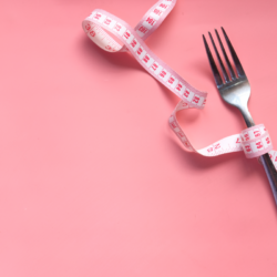 L'image représente une fourchette et un mètre ruban sur un fond rose. Les protéines font-elles maigrir