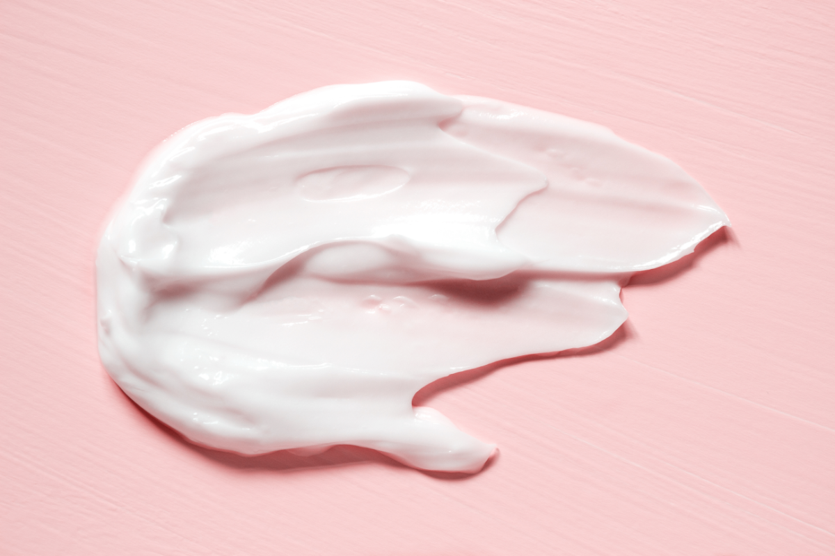 L'image représente de la crème étalée sur un fond rose. Hydrocrème Mon Hydratant Visage pour Peau Atopique Pas Cher Sans Parfum et Disponible en Pharmacie