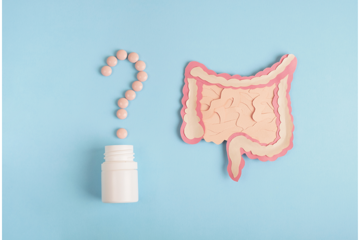 . L'image représente un dessin du système digestif sur un fond bleu, avec un flacon de compléments alimentaires ouverts. les gélules sont alignées pour former un poids d'interrogation!. La naturopathie vers intestinaux