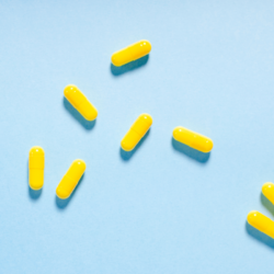 limage représente des gélules jaune sur un fond bleu ciel