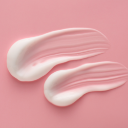 L'image représente de la crème dexeryl étalée sur un fond rose