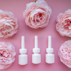 L'image représente un fond rose sur lequel sont posés des laxatifs de type dulcolax et des roses