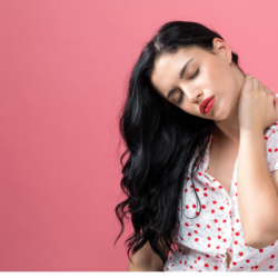Une femme brune qui se tient le cou pour montrer qu'elle souffre probablement de tension