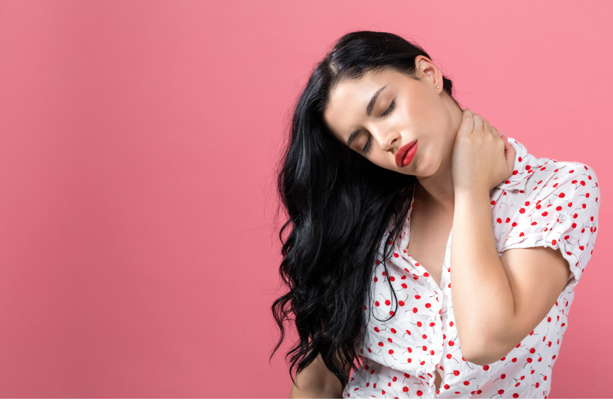 Une femme brune qui se tient le cou pour montrer qu'elle souffre probablement de tension