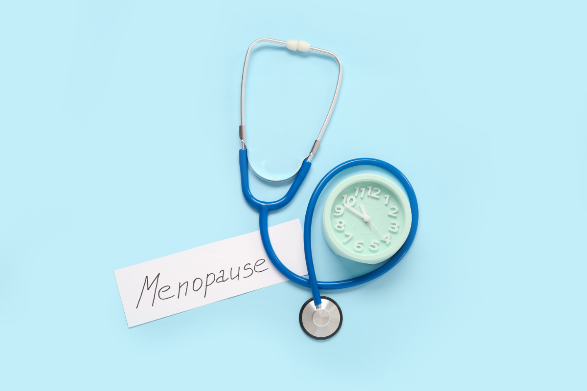 un stéthoscope et un mot qui dit " ménopause", pour illustrer les symptômes de la ménopause comme les bouffées de chaleur, sueurs nocturnes ou encore la sécheresse vaginale.