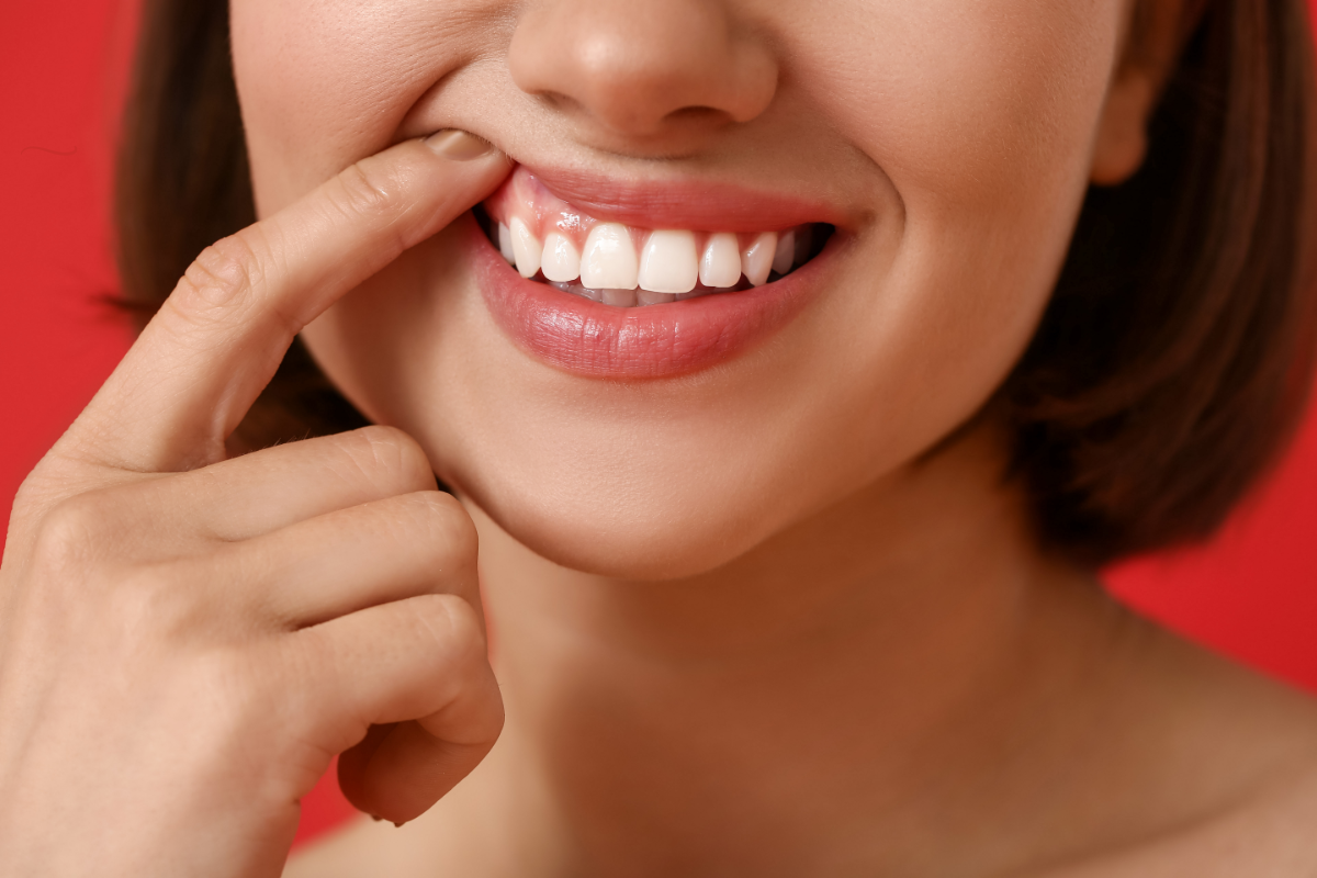 Sourire d'une femme montrant ses gencives en bonne santé, elle ne souffre pas de gingivite.