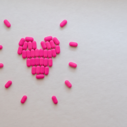 Illustration des bienfaits du NMN en pharmacie, montrant des pilules formant un cœur, symbolisant les effets positifs du Nicotinamide Mononucléotide sur la santé cardiovasculaire et la longévité.