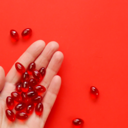 Complément d'Urolithine A en capsules rouges sur fond rouge.