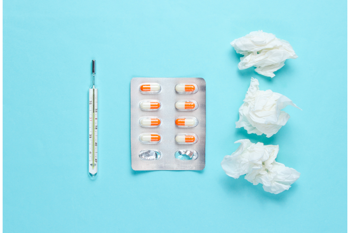 mouchoirs usagers et pilules sur un fond bleu ciel