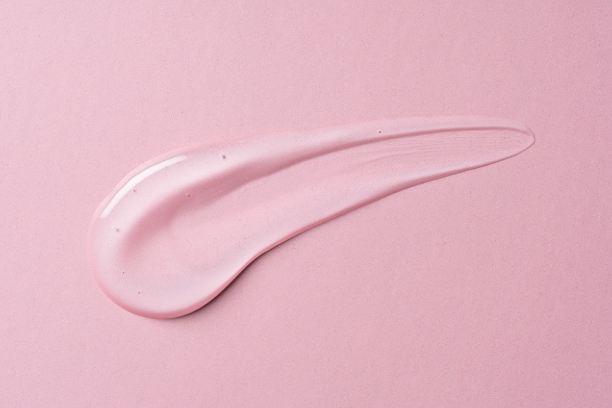 Texture douce et lisse d'un gel d'estradiol rose, illustrant l'hydratation et la fermeté qu'il procure à la peau.
