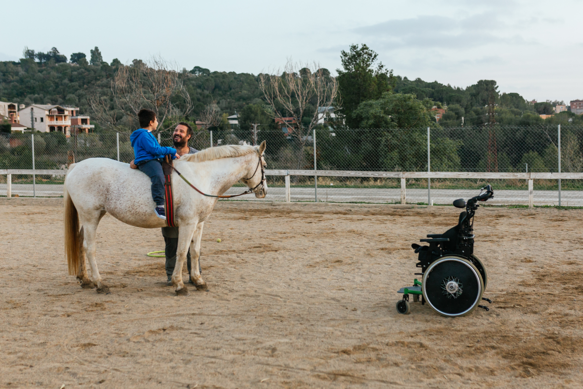 séance de thérapie assistée par le cheval pour un enfant en fauteuil roulant