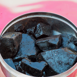 Photo de Shilajit brut dans un récipient métallique, mettant en évidence la texture noire et visqueuse de la substance. Le Shilajit est un complément naturel prisé en médecine traditionnelle, mais il peut contenir des métaux lourds comme le plomb, l’arsenic et le mercure s'il n'est pas purifié. Il est crucial de consommer du Shilajit purifié et testé par des tiers pour éviter les effets secondaires liés à la contamination.