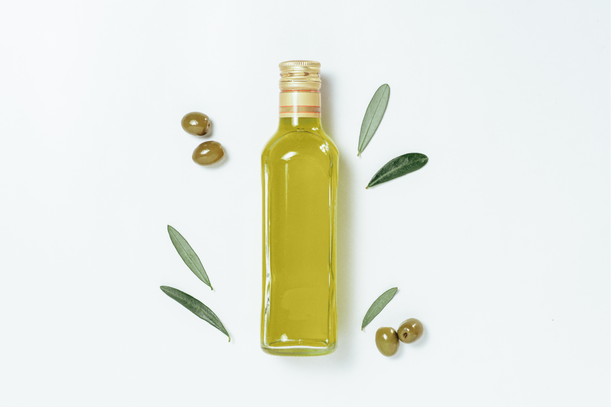 Bouteille d’huile d’olive extra vierge avec feuilles et olives – ingrédient essentiel pour la biodisponibilité et l’efficacité du C60.