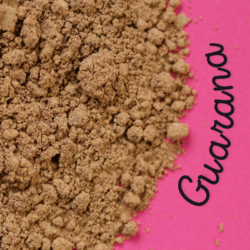 Poudre de guarana sur fond rose, utilisée pour ses propriétés stimulantes et énergisantes en phytothérapie.