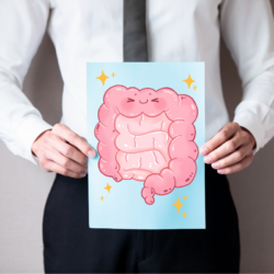 Un homme en costume tenant une illustration d’un intestin souriant, symbolisant l’importance du microbiote intestinal pour la santé globale.