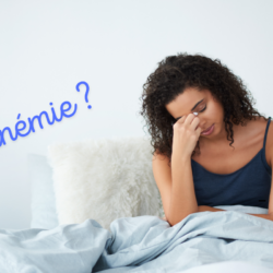 Femme jeune fatiguée au réveil tenant sa tête, possible symptôme d’anémie due à un manque de fer